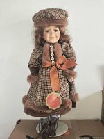 Full view of porcelain doll on stand
