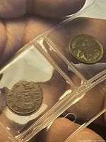 Two Canadian cents in side-by-side plastic flips, reverse of left coin and obverse of right coin