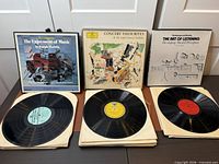 Three boxed sets displayed with one record from each set showing labels