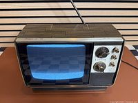 Front view showing powered-on blue raster screen and control panel