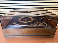 Turntable front view with dust cover closed showing Noresco badge