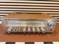 Front angled view showing entire receiver with walnut-grain cabinet and illuminated dial