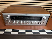 Front angled view showing faceplate, knobs, wood cabinet