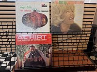 Front view of three shrink-wrapped Christmas LPs on rack: Guy Lombardo Jingle Bells, Doris Day Christmas Album, Al Hirt The Sound of Christmas