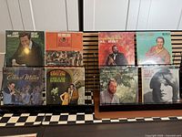 Front view of all eight album jackets displayed on rack