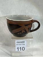 Front view of Allan Bergess stoneware coffee cup on display block