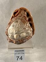 Full view of carved shell lamp shade front, shows brass collar