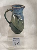 Front view of stoneware cream jug showing handle, spout, glaze transition and slip decoration