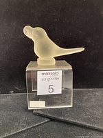 Side view of frosted glass parrot on clear stand