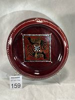 Full view of red lacquered wooden bowl with central bird motif and mother-of-pearl border