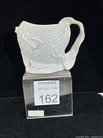 Front view of koi fish porcelain vase on display block