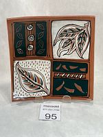 Front view of square redware dish showing divided leaf panels