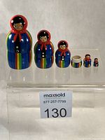Front view of all five dolls and extra half showing faces and stripe pattern