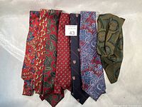 Group shot of seven neckties and ascot showing patterns and colors