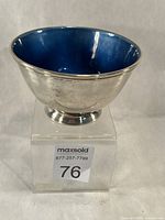 Angled view showing blue enamel interior and silver exterior