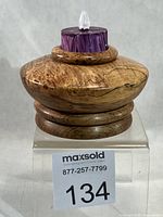 Front view of spalted maple candlestick with LED tealight inserted, MaxSold lot tag visible