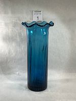 Full view of tall turquoise ribbed glass vase