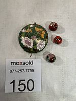 Pendant and three beads laid out showing size reference