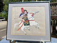 Full view of framed painting on easel