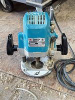Front view of Makita 3612BR router showing full unit with handles and cord