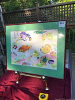 Framed print on easel showing full artwork, frame and mat