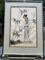 Full view of framed ink wash painting on silk showing Japanese woman beside bamboo