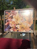 Front view of framed floral print showing lilies and frame