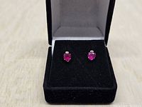 pair of ruby heart stud earrings in display box