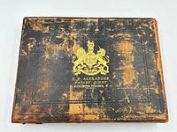 Exterior of original box showing gold coat of arms and patent agent text