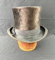 Front and side view of entire top hat on wooden stand
