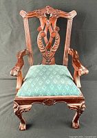 Full front view of armchair showing carved details and upholstery