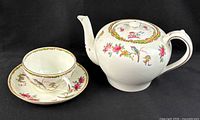 Teapot, teacup on saucer showing pattern and trim