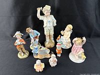Group shot showing all nine figurines with apple for scale