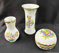 Front view of both vases and lidded box showing pattern and gilt trim