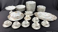 Full view of entire 62-piece Limoges set with Aynsley cup and saucer