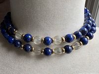 Necklace doubled on display form showing lapis, crystal and gold spacers