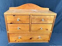 Front view showing five drawers and knobs