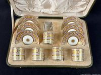 Open case showing five cups and six saucers in fitted velvet interior