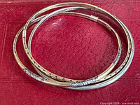 Three intertwined bangles on red surface