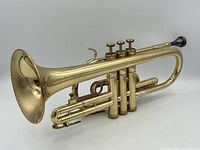 Side view of Olds Ambassador brass cornet showing overall condition and valve layout