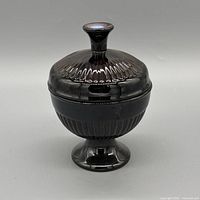 Front view of black iridescent ribbed ceramic covered candy dish on pedestal