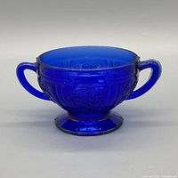 Front view of cobalt blue sugar bowl showing handles and embossed pattern