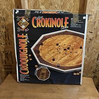 Front of boxed Deluxe Crokinole Game showing board image and accessories
