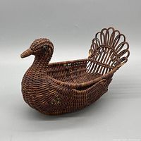 Front angle of duck-shaped wicker basket showing head, body and tail