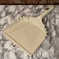 Top angled view of cream EKCO metal dustpan showing logo and wear
