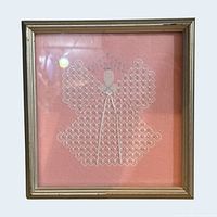 Full view of framed cross-stitch angel in gold-tone frame