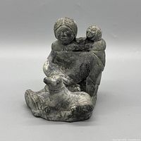 Front view of signed Inuit soapstone sculpture showing mother, child and dog