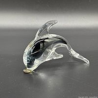 Left profile of clear glass dolphin with black and gold interior accents