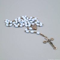 Full rosary coiled showing beads, center medal and crucifix