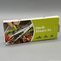 Front of retail box showing Luvcosy five-blade herb shears cutting herbs